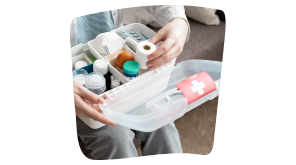 Imagen de una persona adulta sentada en el sofá de su casa con un botiquín abierto sobre sus rodillas en el que busca algún producto para la cura de heridas. Imagen de una persona adulta sentada en el sofá de su casa con un botiquín abierto sobre sus rodillas en el que busca algún producto para la cura de heridas.